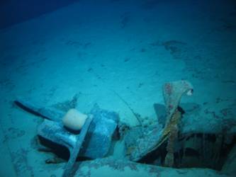 Stbd anchor embedded in steel plate from ship's side in debris field